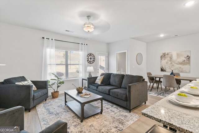 living room with light hardwood / wood-style floors and ceiling fan