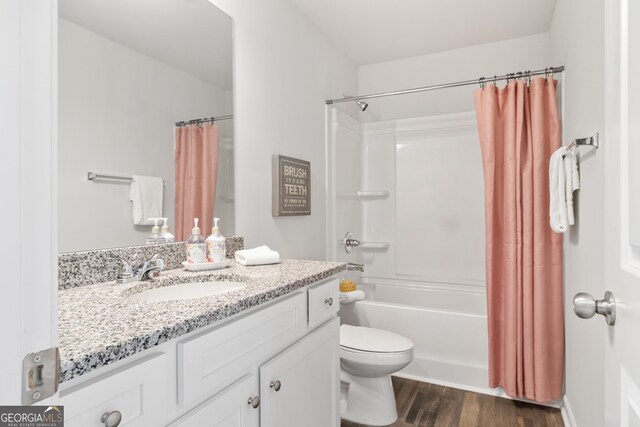 full bathroom with shower / bath combo, vanity, hardwood / wood-style flooring, and toilet