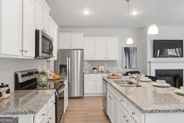 kitchen with sink, white cabinets, pendant lighting, and appliances with stainless steel finishes