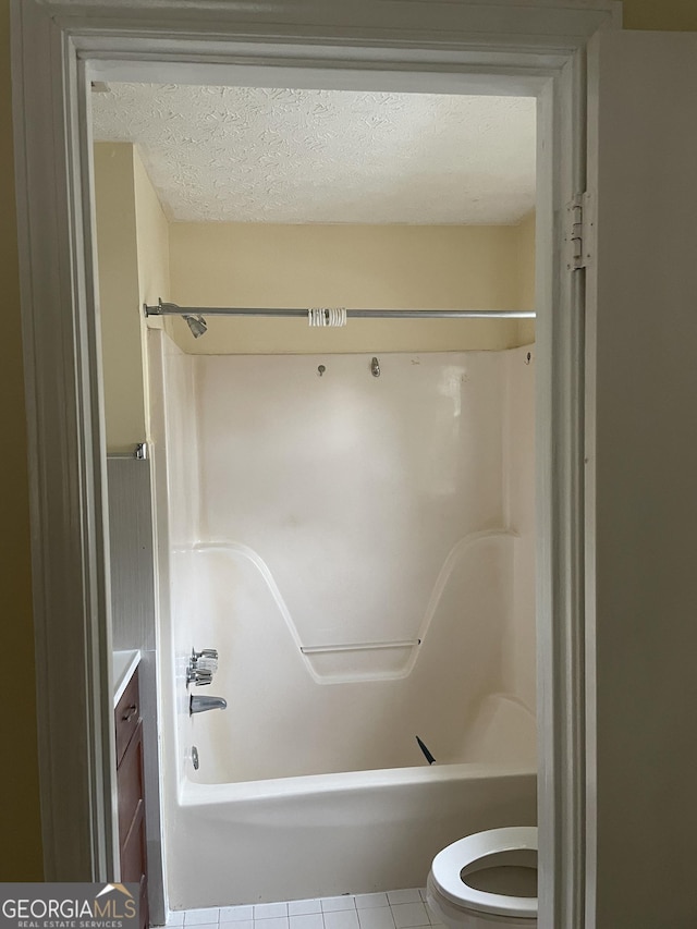 full bathroom featuring shower / bathing tub combination, tile patterned floors, a textured ceiling, and toilet