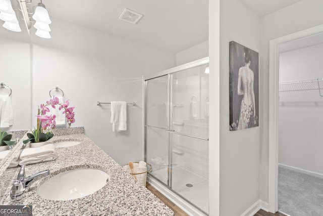 bathroom with vanity, an enclosed shower, and an inviting chandelier