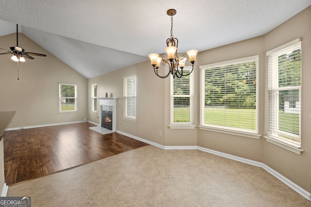 interior space featuring a wealth of natural light, lofted ceiling, a textured ceiling, and wood-type flooring