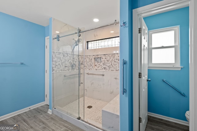 bathroom featuring toilet, hardwood / wood-style flooring, and plenty of natural light