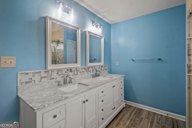 bathroom featuring vanity, hardwood / wood-style floors, and backsplash