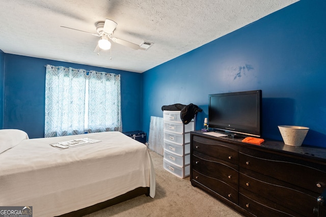 carpeted bedroom featuring a textured ceiling and ceiling fan