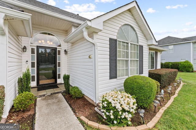 entrance to property featuring a lawn