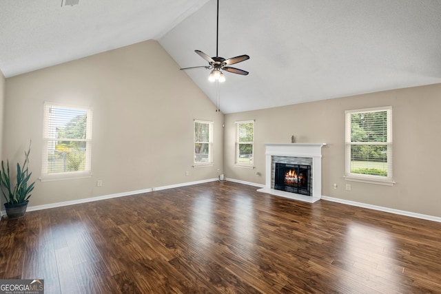 unfurnished living room featuring dark wood-type flooring, ceiling fan, and plenty of natural light