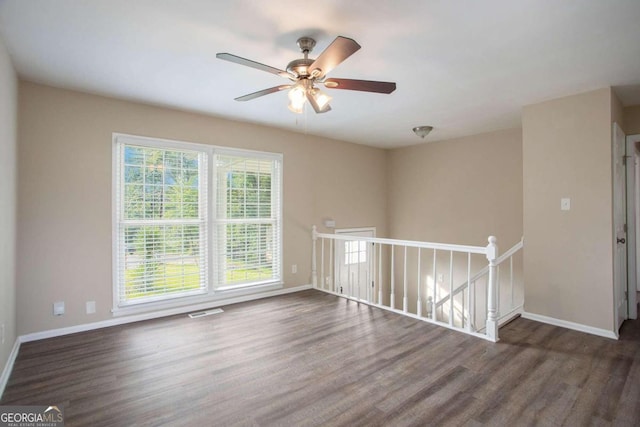 empty room with dark hardwood / wood-style floors and ceiling fan