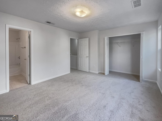 6531 Arbor Gate Dr SW # 12, Mableton, GA 30126 - unfurnished bedroom with connected bathroom, a closet, light colored carpet, and a textured ceiling