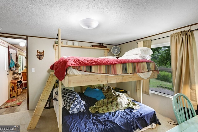 bedroom featuring ornamental molding, a textured ceiling, and wood-type flooring