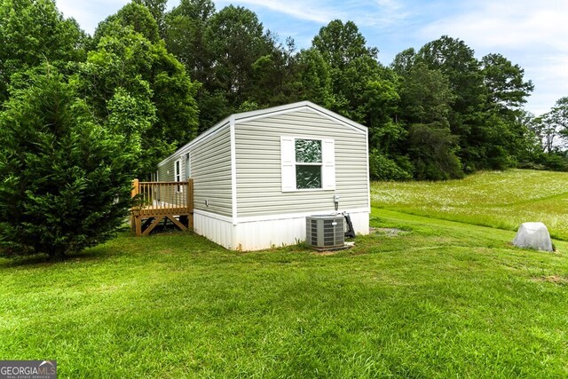 view of outdoor structure with a yard and central AC unit