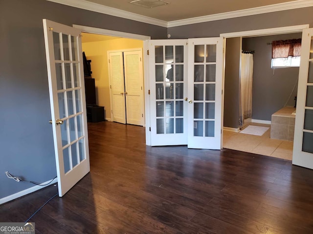 unfurnished room with crown molding, french doors, and dark wood-type flooring