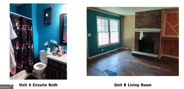 bathroom with a fireplace, a textured ceiling, brick wall, toilet, and vanity