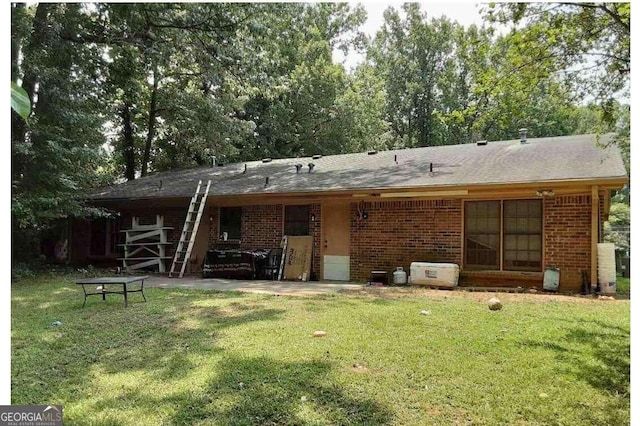 rear view of house with a patio area and a lawn