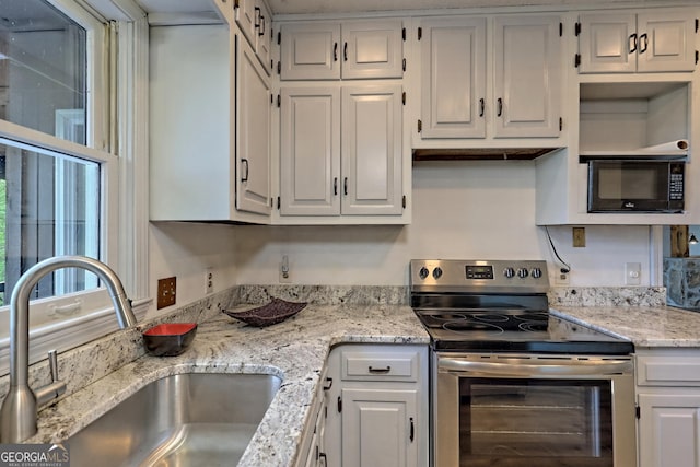 kitchen featuring white cabinetry, light stone counters, sink, and stainless steel range with electric cooktop