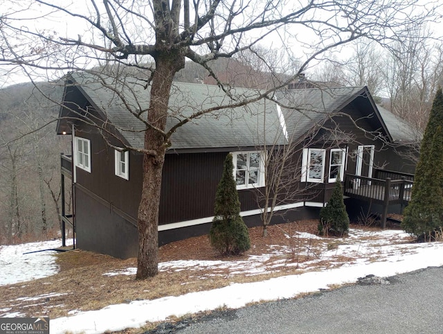 snow covered property with a deck