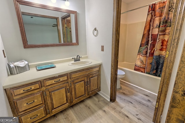 full bathroom featuring shower / bathtub combination with curtain, wood-type flooring, toilet, and vanity