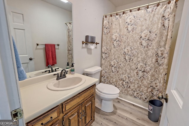 bathroom featuring wood-type flooring, vanity, and toilet