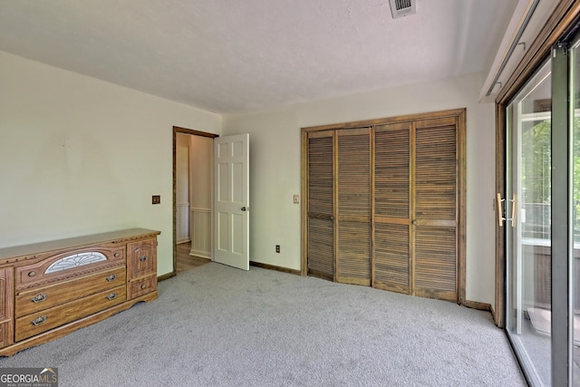 unfurnished bedroom featuring a closet, access to exterior, and light carpet