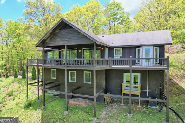 back of property featuring a sunroom and a deck