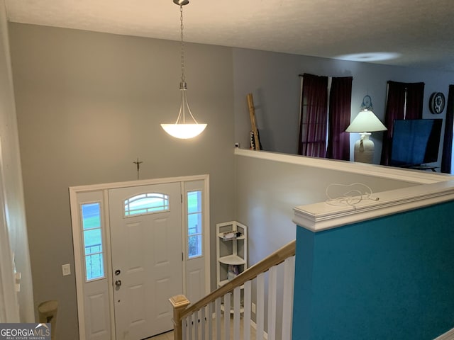 foyer entrance with a textured ceiling