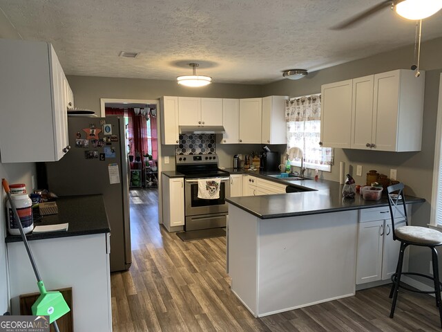 kitchen featuring sink, stainless steel appliances, light hardwood / wood-style flooring, decorative backsplash, and white cabinets