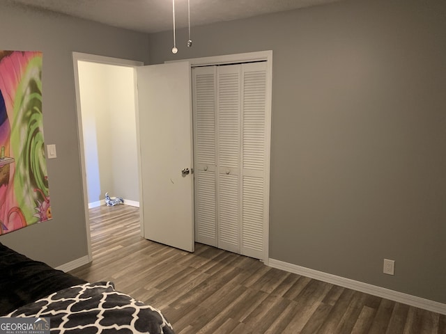 bedroom with wood-type flooring, a textured ceiling, and a closet