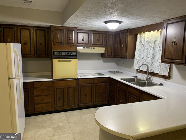 kitchen featuring sink, wall oven, stovetop, white fridge, and a textured ceiling