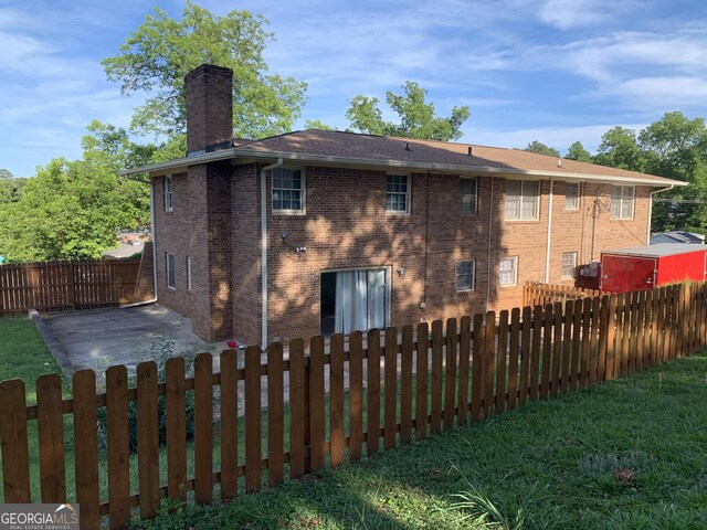 back of property featuring a patio area and a lawn