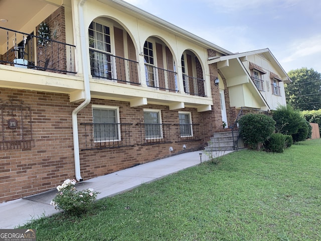 exterior space featuring a balcony and a yard