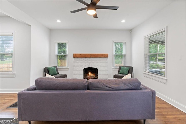 living room with hardwood / wood-style floors, a fireplace, ceiling fan, and plenty of natural light