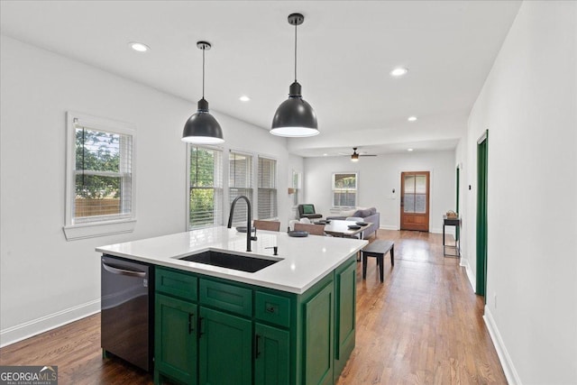 kitchen with hanging light fixtures, sink, stainless steel dishwasher, and a kitchen island with sink