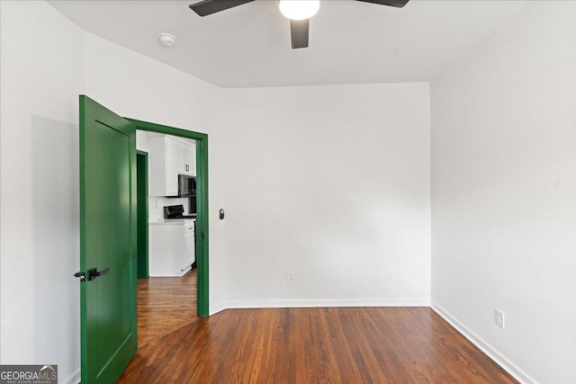 spare room featuring ceiling fan and dark hardwood / wood-style flooring