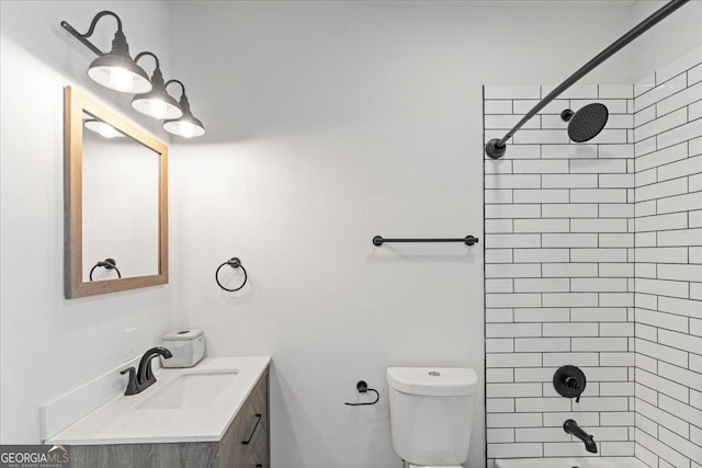 full bathroom featuring tiled shower / bath combo, vanity, and toilet