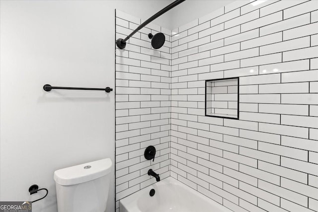 bathroom with tiled shower / bath combo and toilet