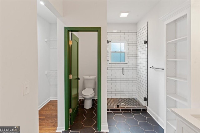 bathroom featuring an enclosed shower and toilet