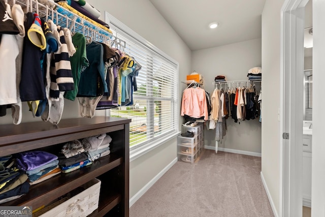 walk in closet featuring light carpet