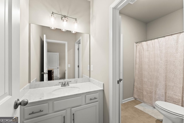 bathroom featuring tile patterned flooring, vanity, and toilet