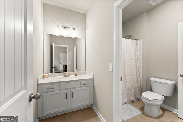 bathroom with tile patterned flooring, vanity, and toilet