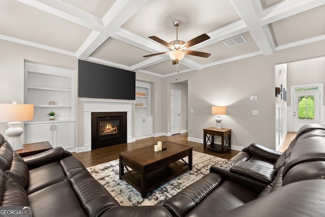 living room featuring coffered ceiling, crown molding, ceiling fan, beamed ceiling, and dark hardwood / wood-style flooring