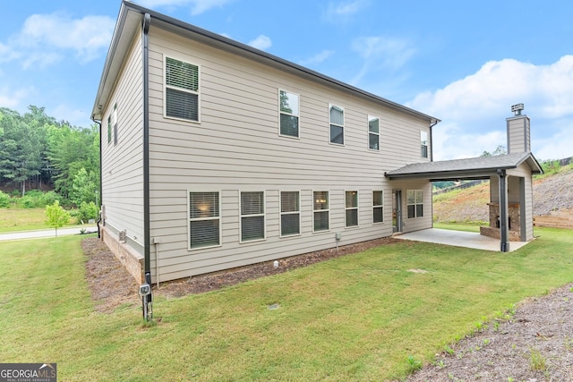 back of house with a patio and a lawn