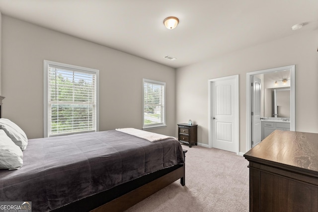 carpeted bedroom featuring ensuite bath