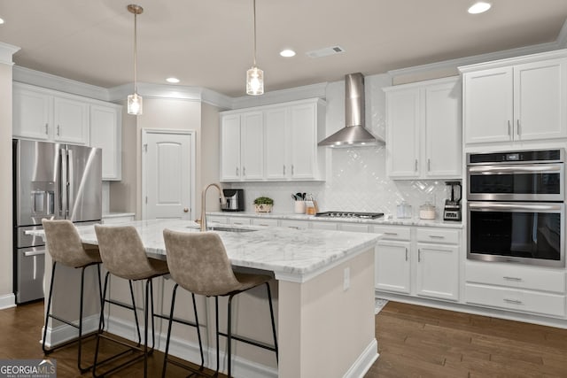 kitchen featuring stainless steel appliances, white cabinetry, and wall chimney range hood