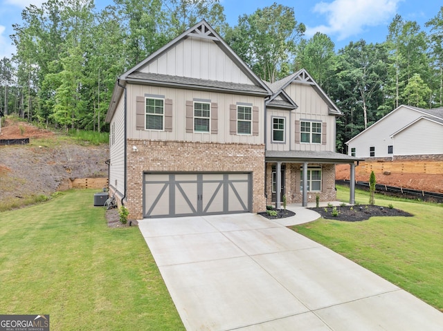 view of front of house with a front lawn, central AC unit, and a garage