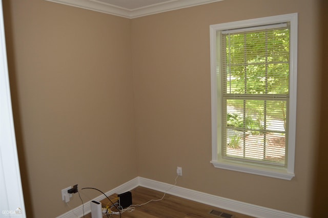 spare room with crown molding and wood-type flooring