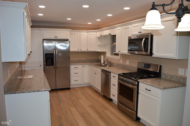 kitchen with stainless steel appliances, hanging light fixtures, white cabinetry, light stone countertops, and light wood-type flooring