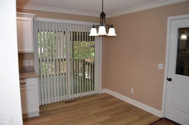 unfurnished dining area with ornamental molding and light wood-type flooring