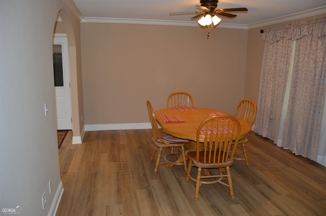 dining room with ceiling fan, ornamental molding, and light wood-type flooring