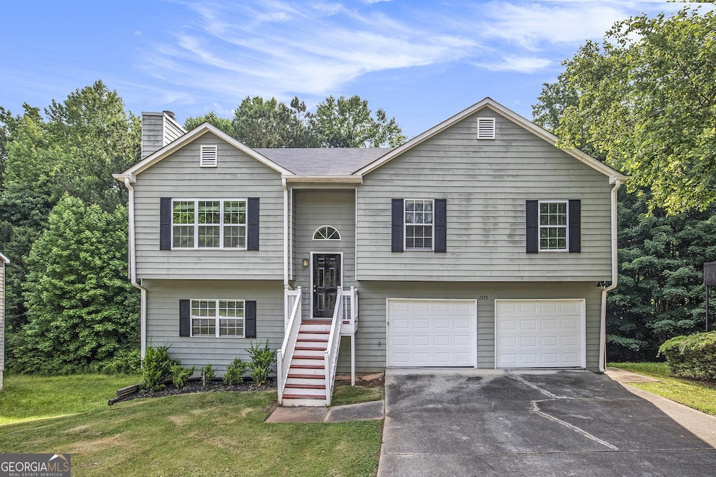 bi-level home with a front yard and a garage