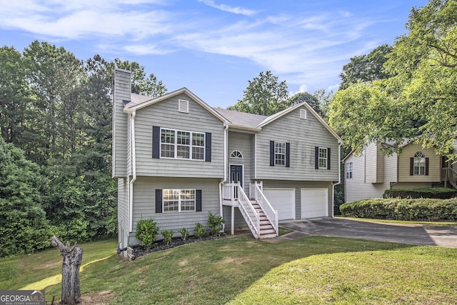 raised ranch featuring a front lawn and a garage